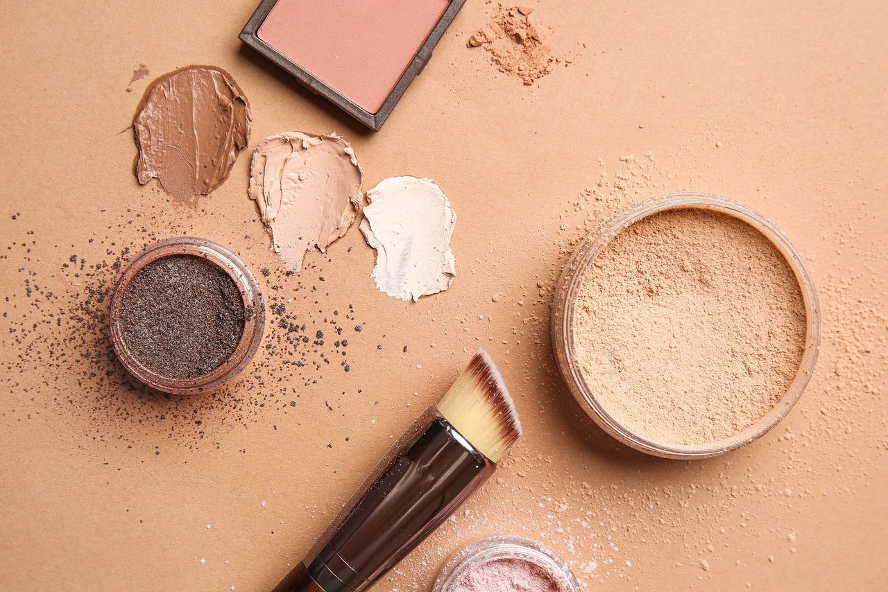 Beauty Shopify Theme Beautify. Makeup products including a brush, powders, and blush on a beige background