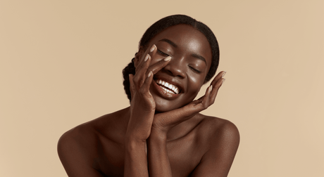 Beauty Shopify Theme Beautify. Woman with a radiant smile touching her face against a beige background